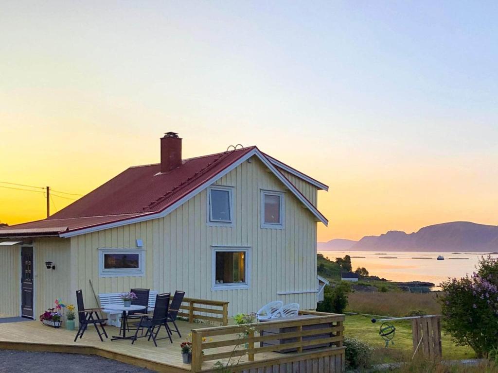 a house with a table and chairs on a deck at 4 person holiday home in ALSVÅG in Alsvåg