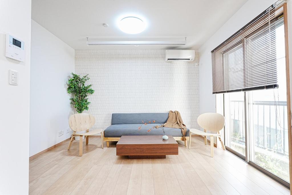 a living room with a blue couch and a table at Manere in Tokyo
