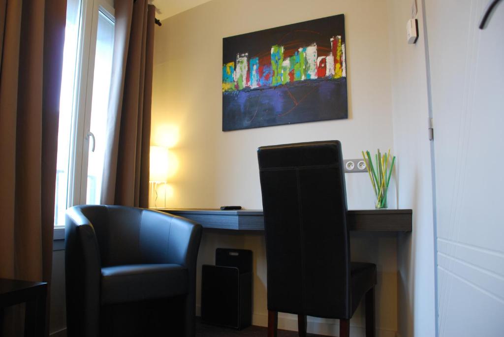 Cette chambre comprend un bureau, une chaise et un moniteur. dans l'établissement Ruthenium Hotel, à Rodez