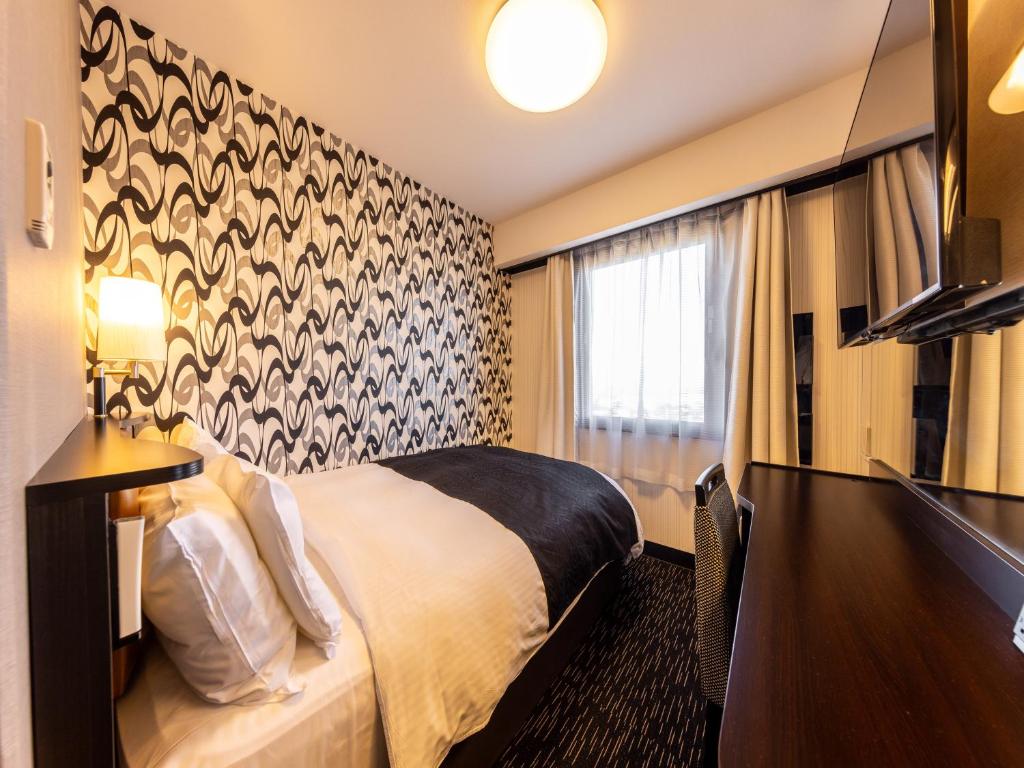 Postel nebo postele na pokoji v ubytování APA Hotel Uozu Ekimae