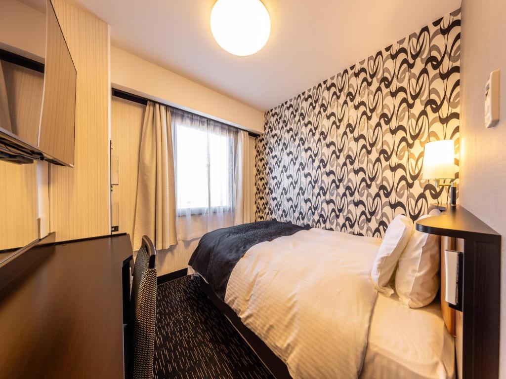 Postel nebo postele na pokoji v ubytování APA Hotel Uozu Ekimae