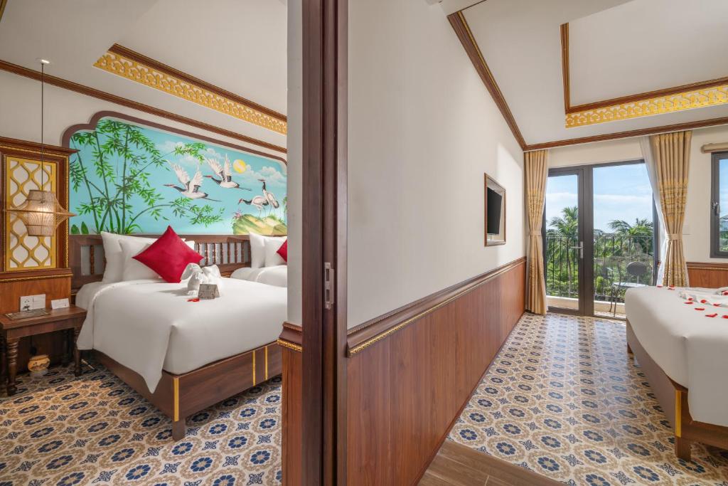Postel nebo postele na pokoji v ubytování Hoi An Babylon Riverside Hotel & Spa