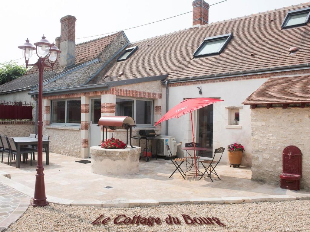 a house with a patio with a red umbrella at Maison de Ville avec Spa et Sauna près d'Orléans - FR-1-590-547 in Chécy