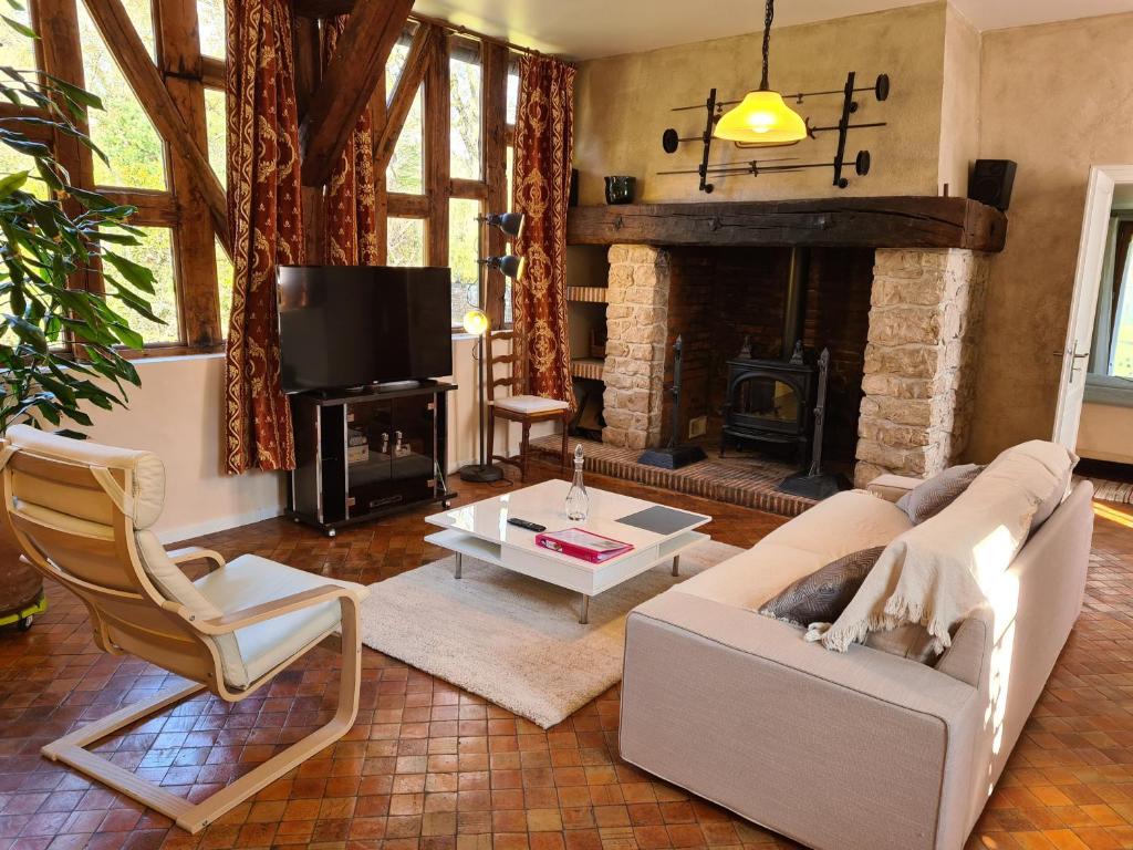 ein Wohnzimmer mit Couch und Kamin in der Unterkunft Longère de charme rénovée, 2 chambres, proche Orléans - FR-1-590-553 in Ligny-le-Ribault