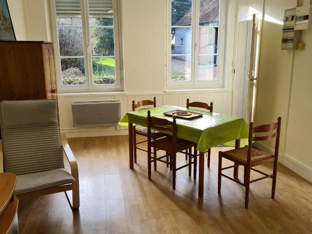 a dining room with a green table and chairs at Studio cosy proche d'Orléans avec parking et animaux sur place - FR-1-590-558 in Bucy-Saint-Liphard