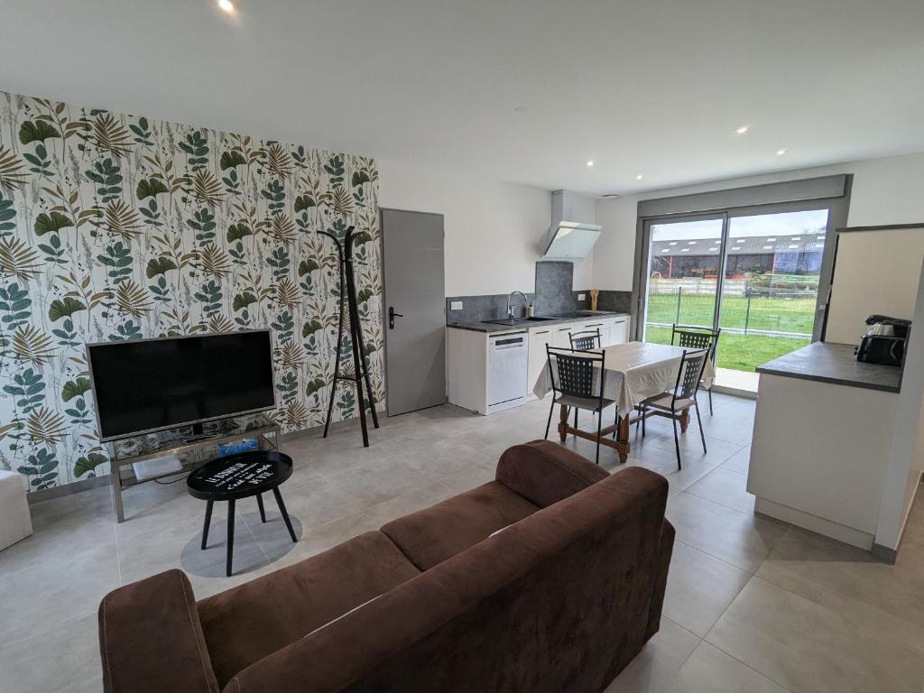 a living room with a couch and a table and a kitchen at Maison rénovée avec jardin et parking, proche Orléans, animaux acceptés - FR-1-590-561 in Épieds-en-Beauce