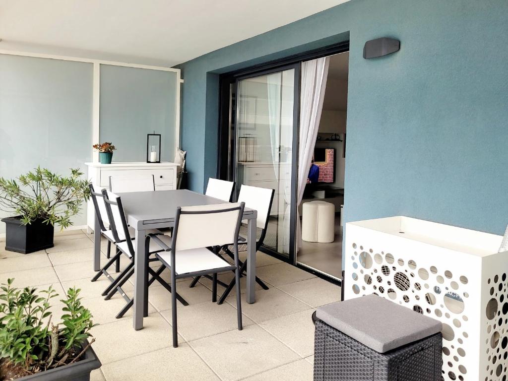 a dining room with a table and chairs on a balcony at T3 moderne avec clim et wifi, proche port et mer, box fermé - FR-1-794-157 in Canet-en-Roussillon