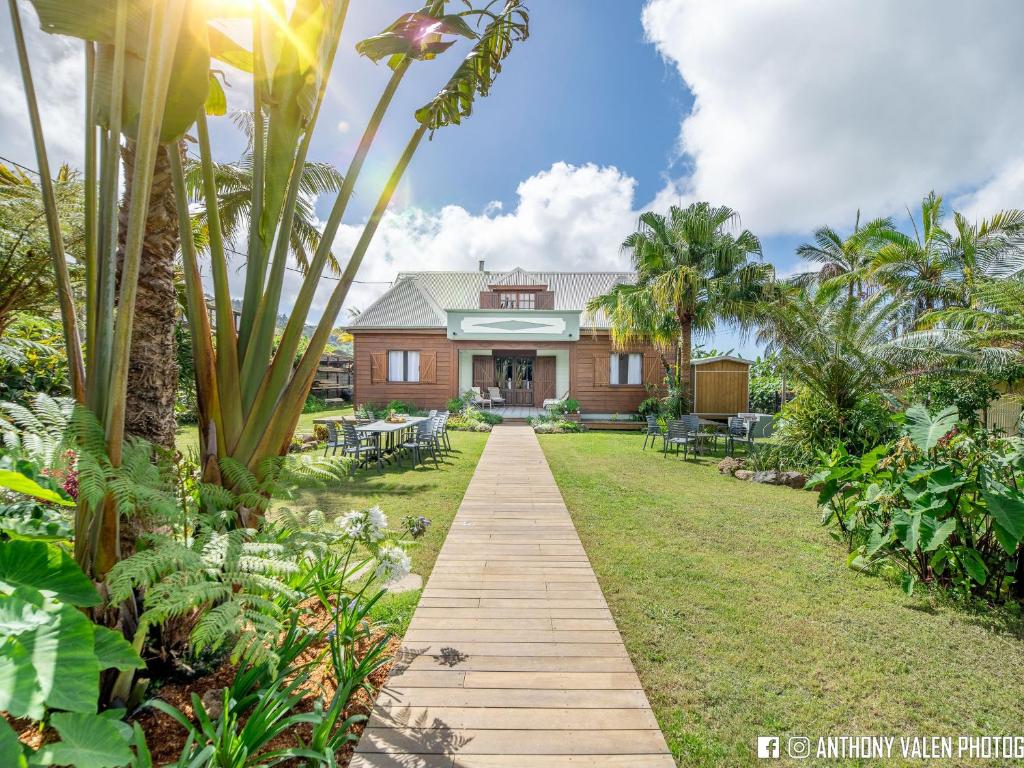 a house with a wooden walkway in front of a yard at Villa spacieuse avec jardin, cheminée et billard, 5 chambres pour 10 pers. - FR-1-786-35 in Les Avirons