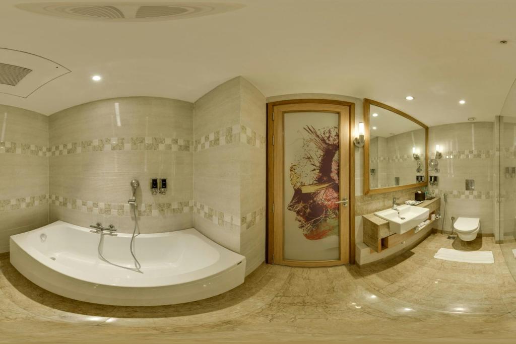 a large bathroom with a tub and a sink at Fairfield by Marriott Lucknow in Lucknow