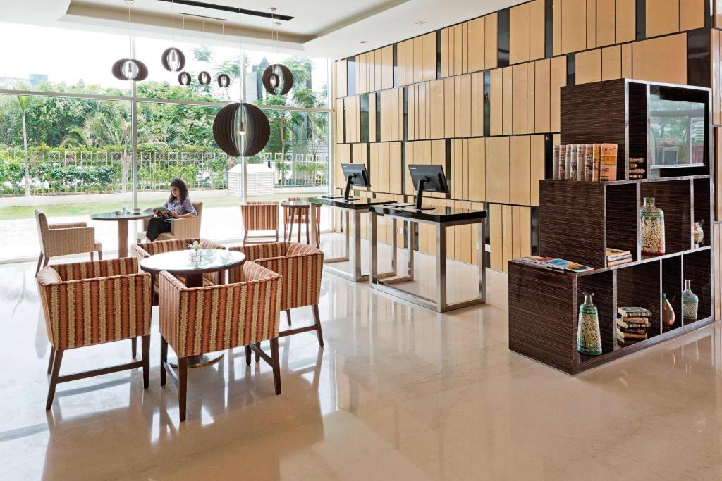 a woman sitting at a table in a restaurant at Fairfield by Marriott Lucknow in Lucknow