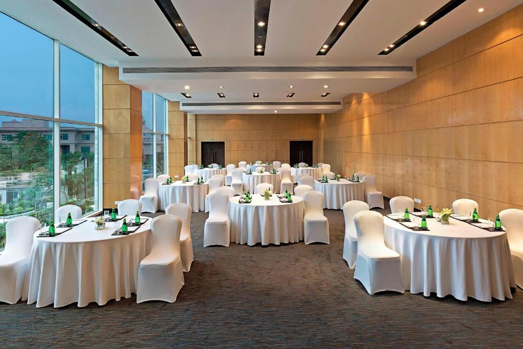 a banquet hall with white tables and white chairs at Fairfield by Marriott Lucknow in Lucknow