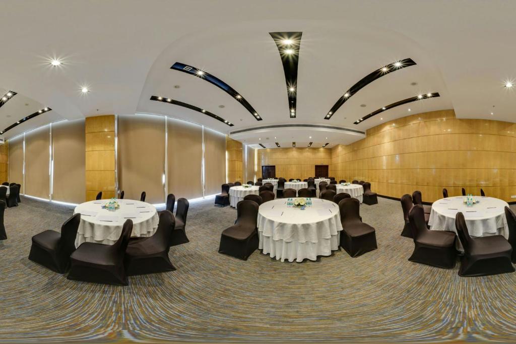 a banquet hall with white tables and black chairs at Fairfield by Marriott Lucknow in Lucknow