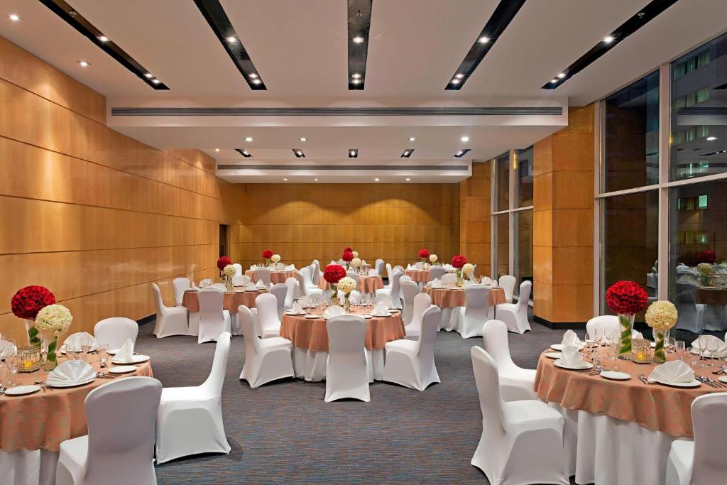 a banquet hall with white tables and white chairs at Fairfield by Marriott Lucknow in Lucknow
