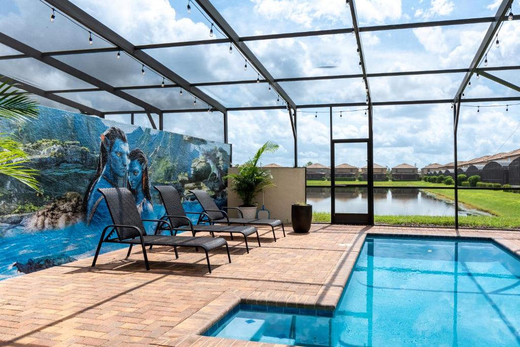 a patio with a pool with chairs and a painting at Modern 5BR TwnHome w Private Pool Near Disney 358 in Kissimmee