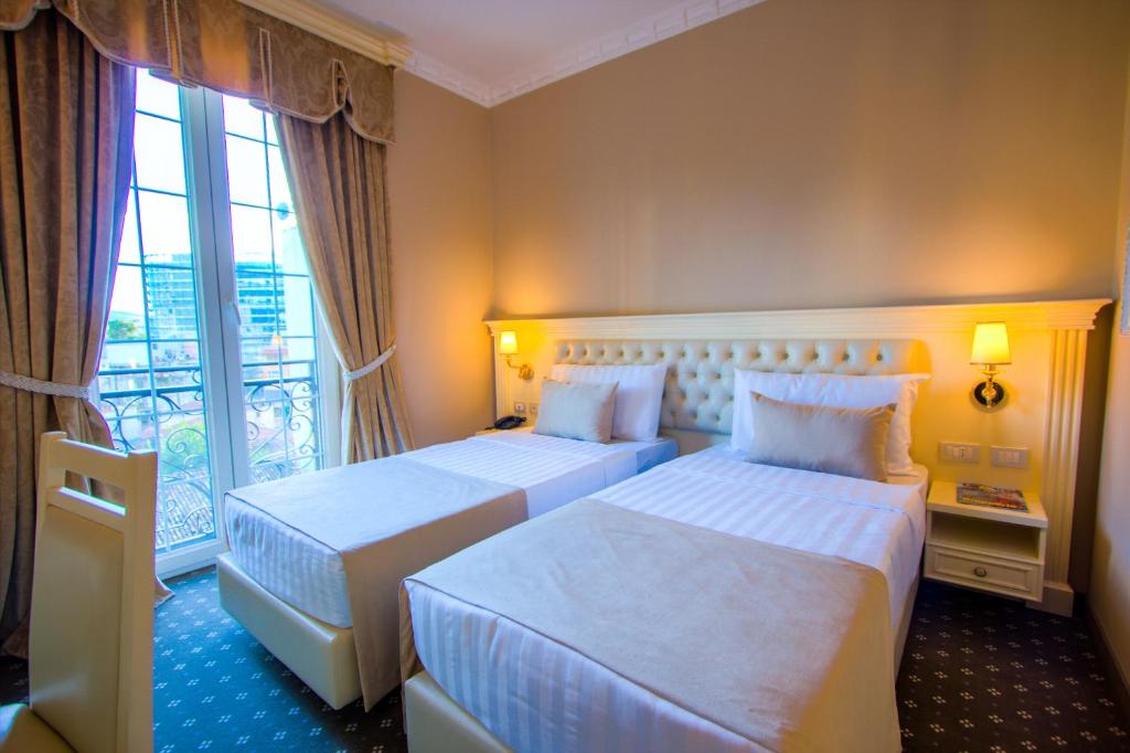 a hotel room with two beds and a window at Lot Boutique Hotel by Hotels and Preference in Tirana