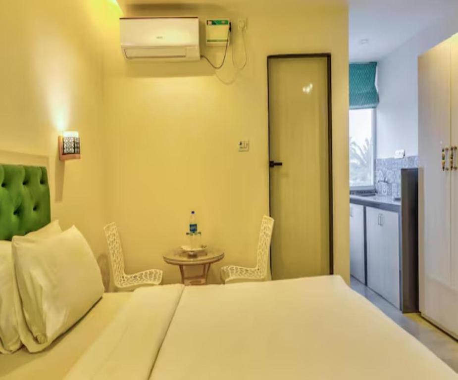 a bedroom with a bed and a table with chairs at The Luma House-TBV in Baga