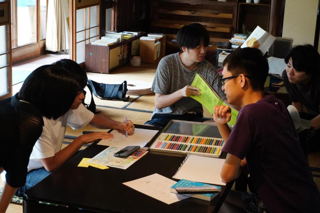 a group of people sitting around a table at Guesthouse SETOUCHI LIFE in Kure
