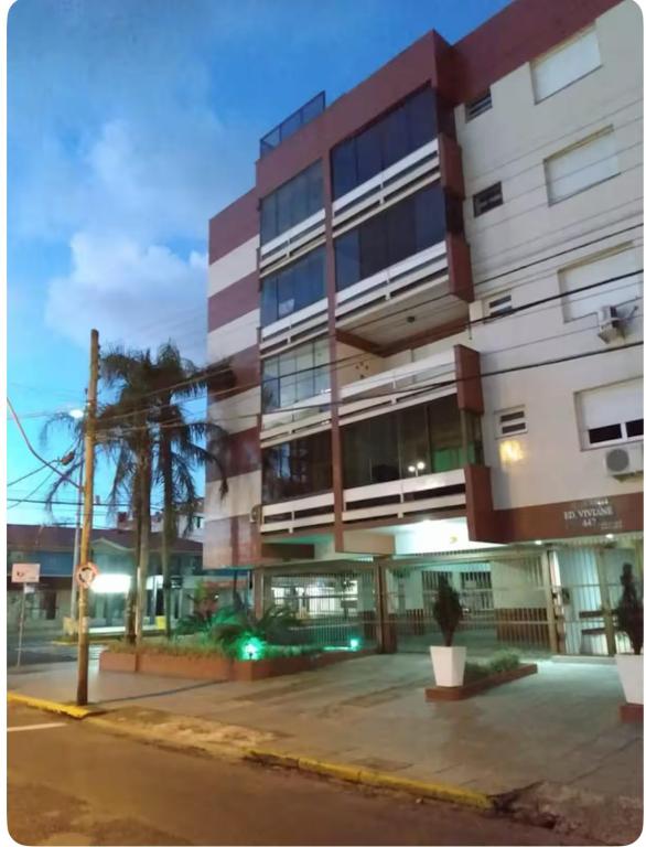 a large building with a street in front of it at Aconchegante apartamento 2 dormitórios no centro com vaga in Capão da Canoa