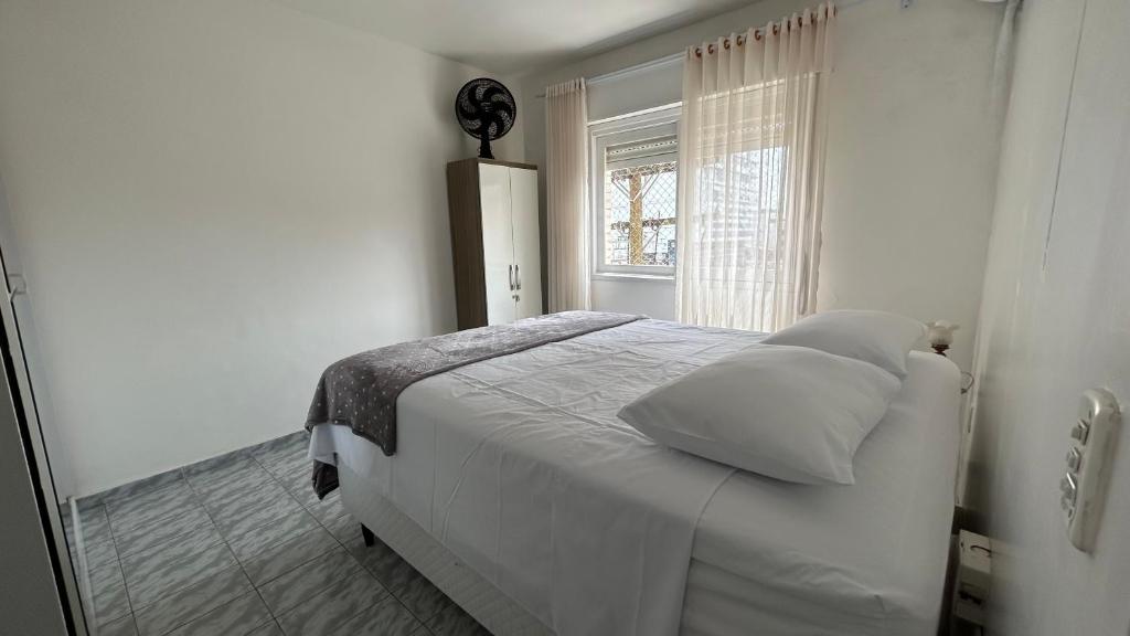 En eller flere senge i et værelse på Aconchegante apartamento 2 dormitórios no centro com vaga