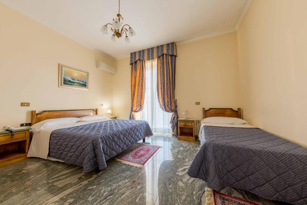 pokój hotelowy z dwoma łóżkami i oknem w obiekcie Hotel Aquila w mieście Orte