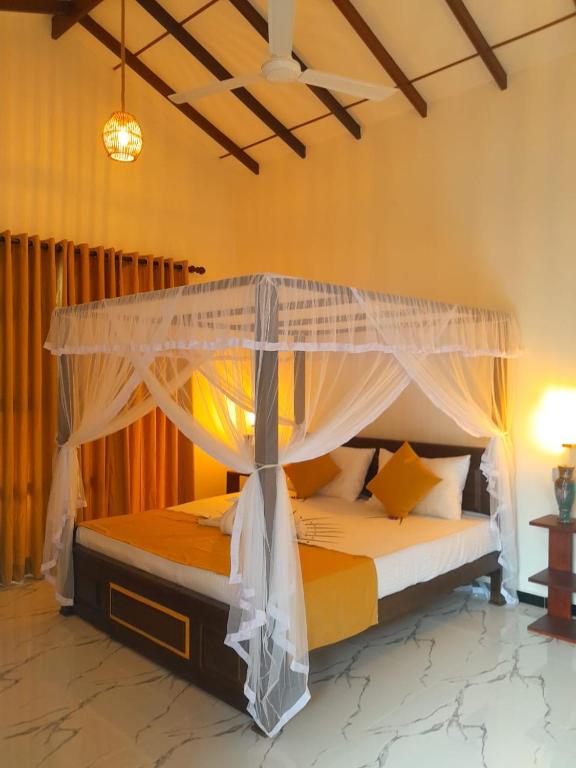 a bedroom with a bed with a canopy at Serendib Villa in Ahangama