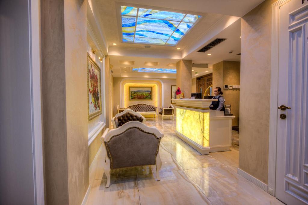 a woman standing at a counter in a hotel lobby at Lot Boutique Hotel by Hotels and Preference in Tirana