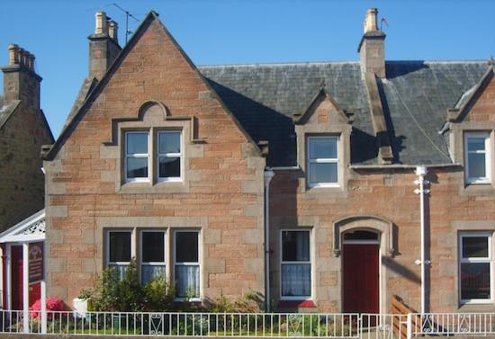 a brick house with a fence in front of it at Jacobite Rose in Inverness