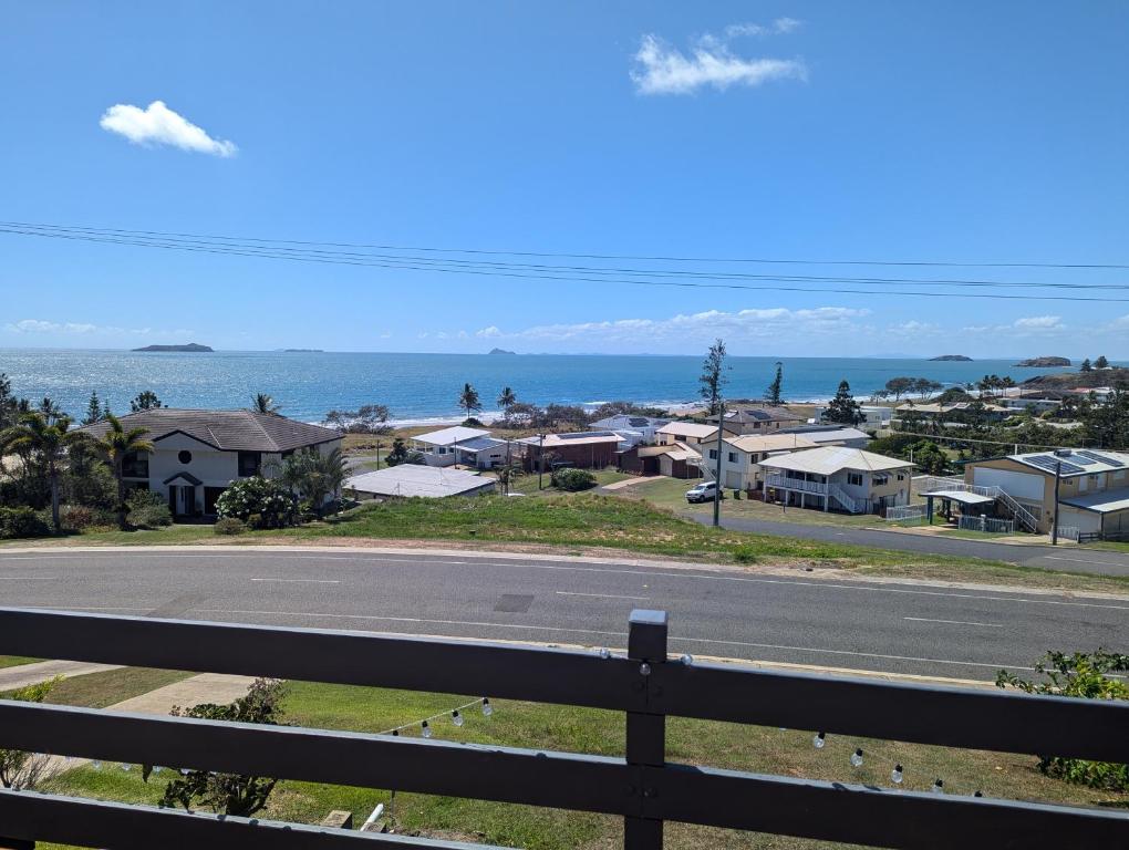 an empty road with houses and the ocean in the background at Ocean view in Emu Park in Emu Park