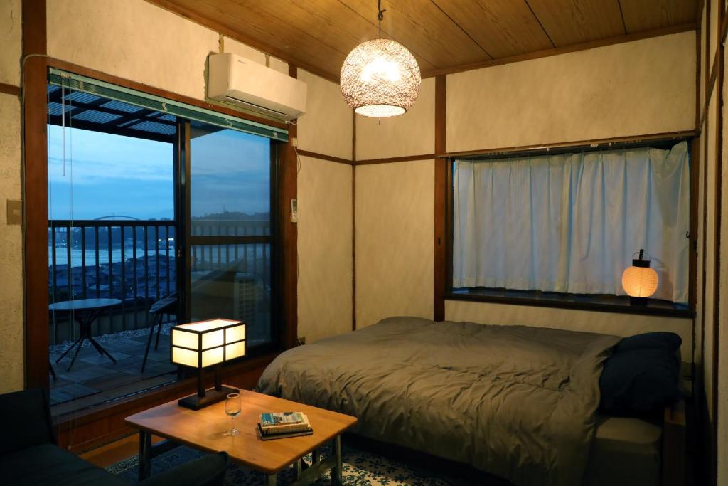 a bedroom with a bed and a view of a balcony at Guesthouse SETOUCHI LIFE in Kure