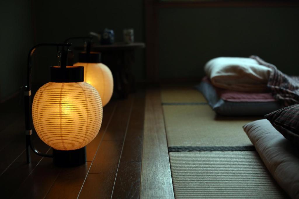 a lamp in a living room with a couch at Guesthouse SETOUCHI LIFE in Kure