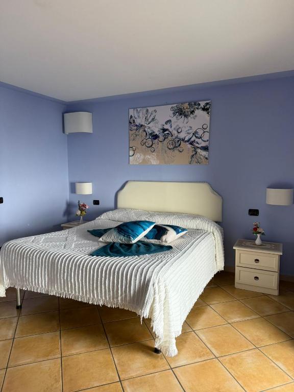 a bedroom with a bed with a blue wall at Luna Convento Copanello B&B in Stalettì