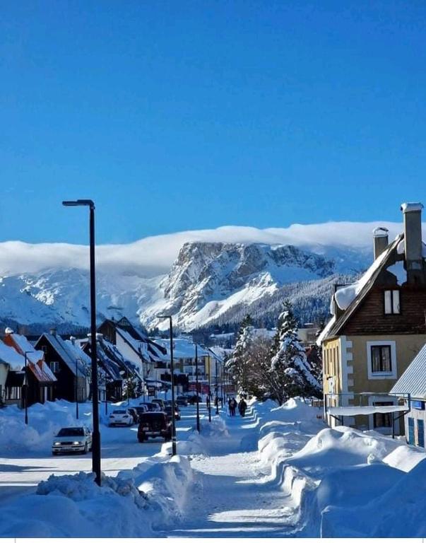 eine schneebedeckte Straße mit einem Berg im Hintergrund in der Unterkunft Zabljak Dela Ma in Žabljak