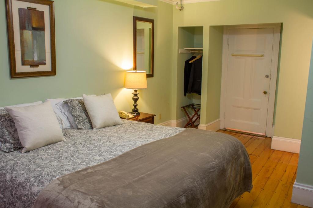 a bedroom with a bed and a lamp and a closet at Beacon Inn 1750 in Brookline