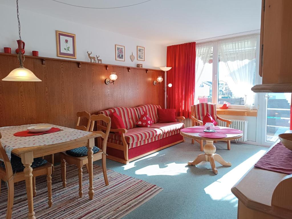 a living room with a couch and a table at 2-Raum FeWo Lichtnelke - Hallenbad & Sauna in Fischen