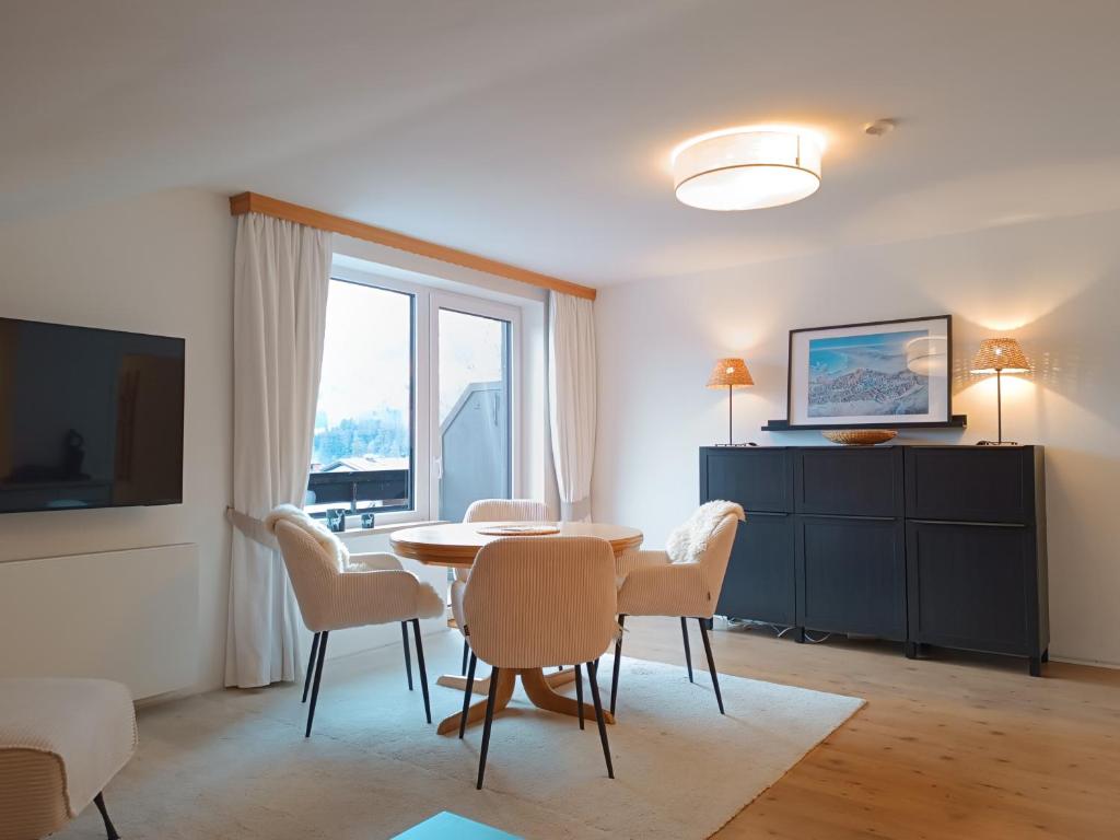 a living room with a dining room table and chairs at 2-Raum FeWo Alina - Hallenbad & Sauna in Fischen