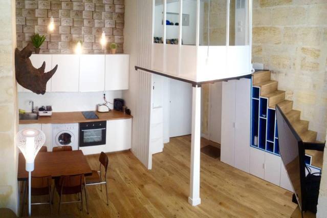 une cuisine et une salle à manger avec une table et un escalier dans l'établissement Appartement St Michel, à Bordeaux