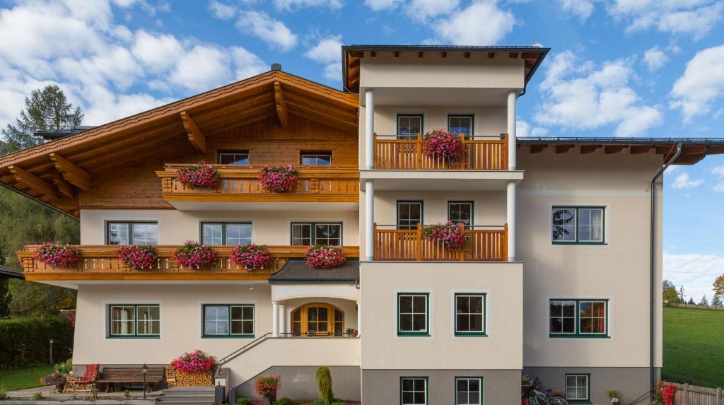 a house with flower boxes on the balconies at Pension Steiermark in Schladming