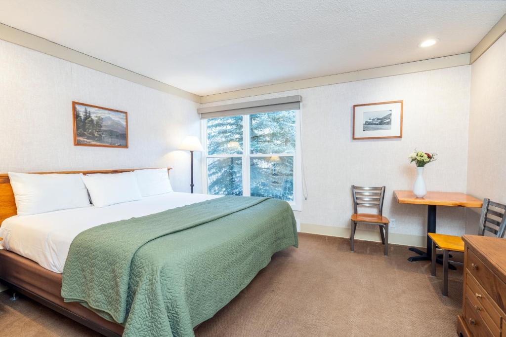 a bedroom with a bed and a desk and a window at Mountainside Inn 211 by Alpine Lodging Telluride in Telluride