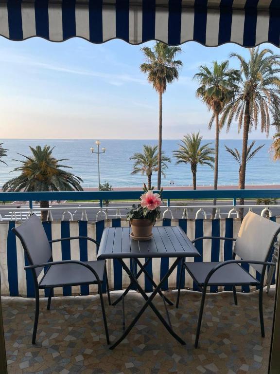 une table et des chaises sur un balcon avec l'océan dans l'établissement Nice Promenade des Anglais Your Seafront Flat, à Nice
