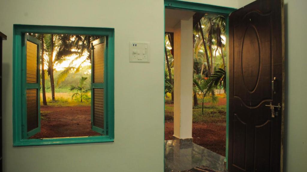 una puerta con ventana y vistas a un patio en India Yoga Village, en Canacona