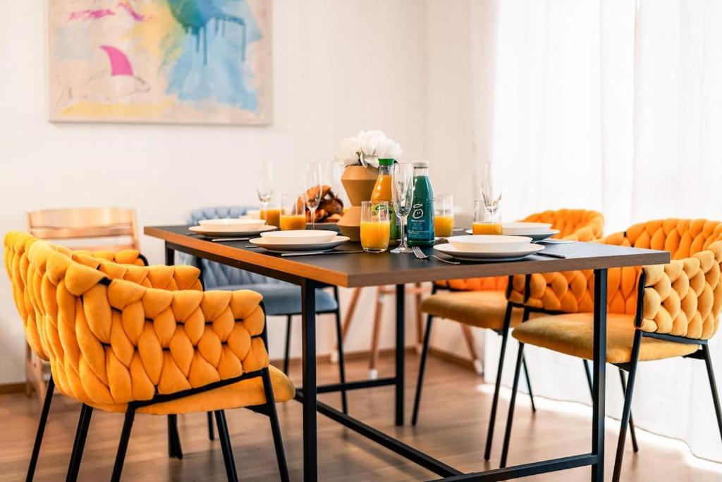 een eettafel en stoelen met oranje stoelen bij Apartment Nautilus in Seenähe in Friedrichshafen