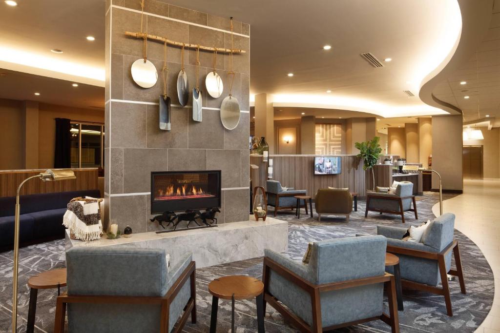 a hotel lobby with a fireplace and chairs at Fairfield Inn & Suites By Marriott Louisville Northeast in Louisville