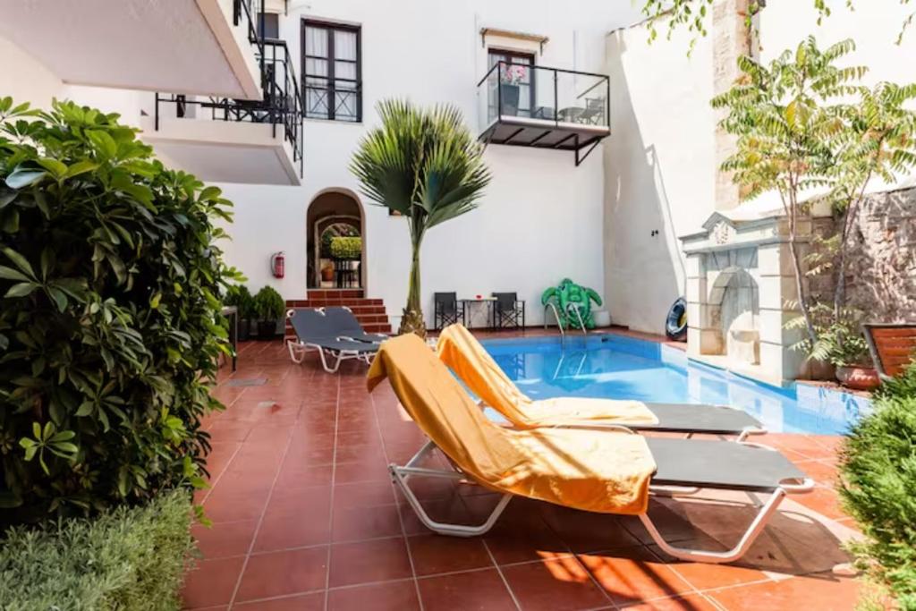 a patio with chairs and a swimming pool at Calergi Residence - Boutique Resort in Atsipopoulo