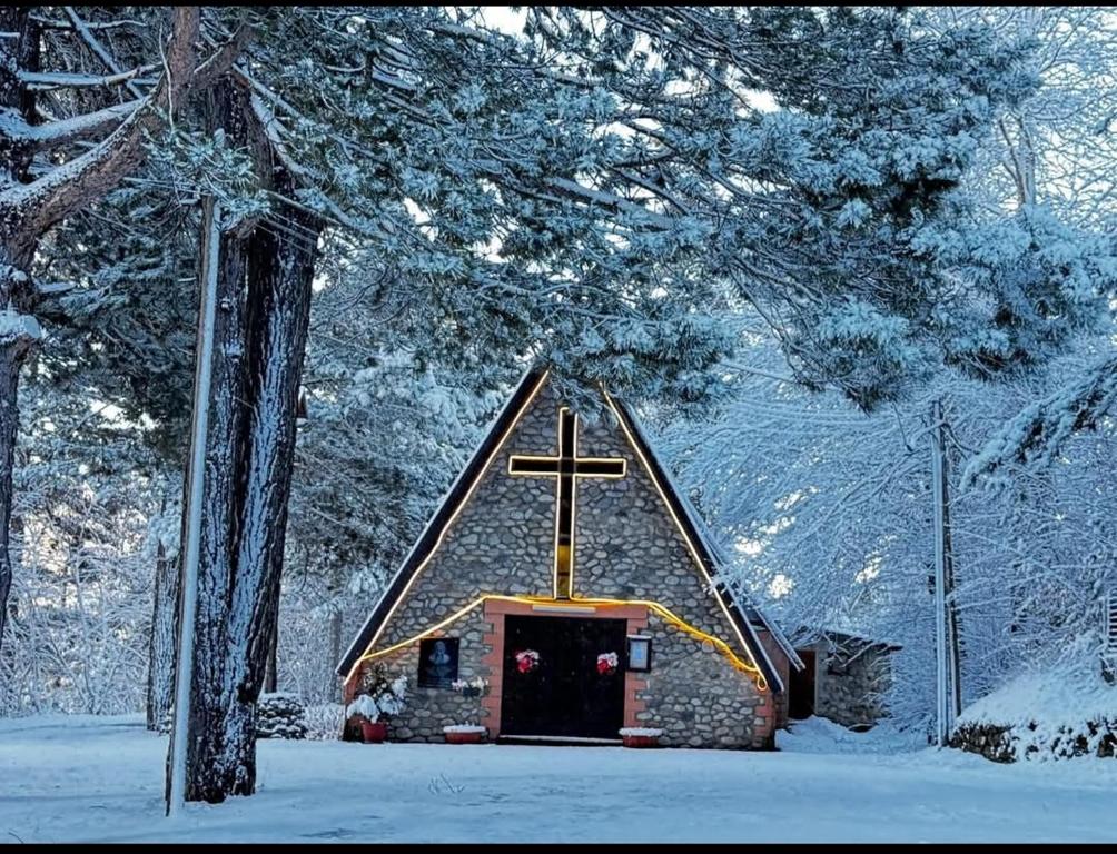 a church with a cross on top of it in the snow at Pungitopo in Torre Caprara
