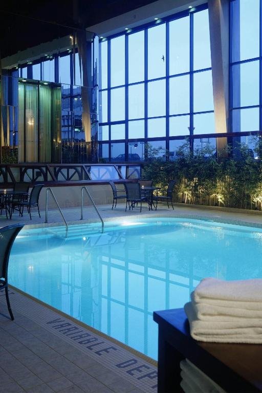 カルガリーにあるDelta Hotels Calgary Airport In-Terminalの窓のある建物内の大型スイミングプール