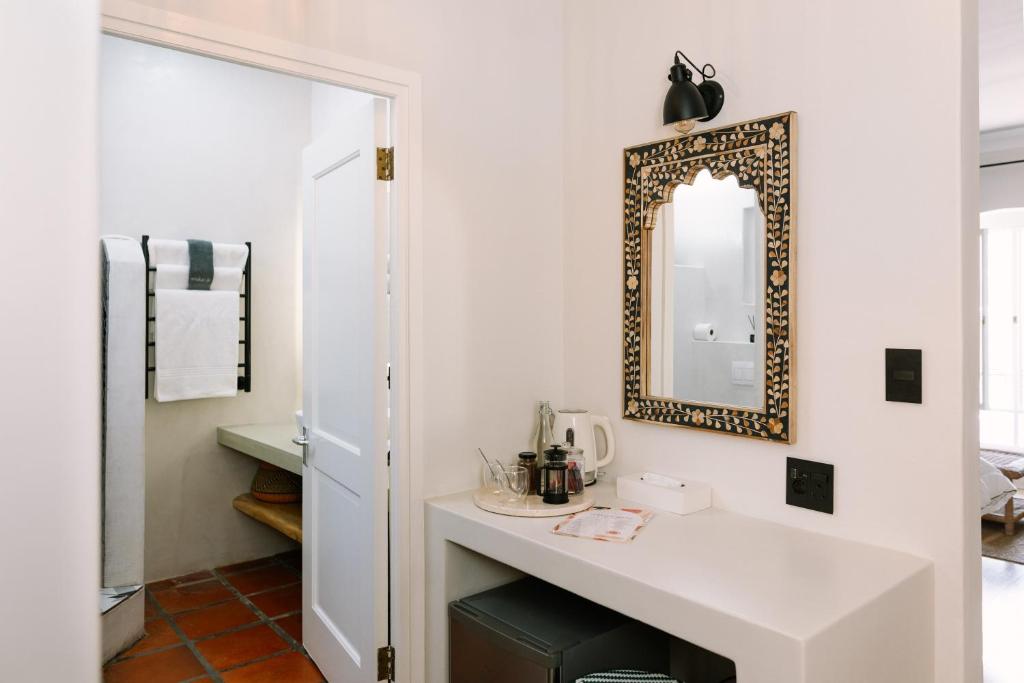 a bathroom with a sink and a mirror on the wall at Auberge Burgundy Boutique Hotel & Spa in Hermanus
