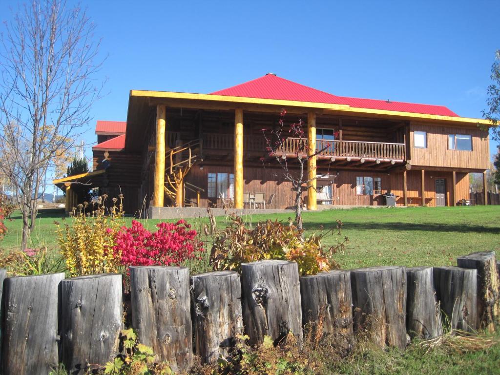 una valla de madera frente a una casa en Smithers Driftwood Lodge en Smithers