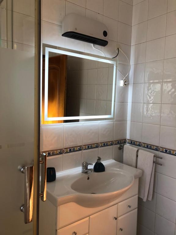 a bathroom with a sink and a mirror at Casa das Conchas in Ericeira