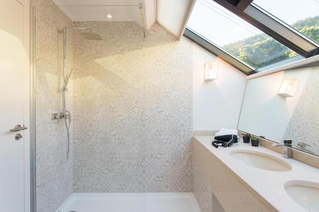 een badkamer met een wastafel, een douche en een raam bij Four Points by Sheraton Sesimbra in Sesimbra