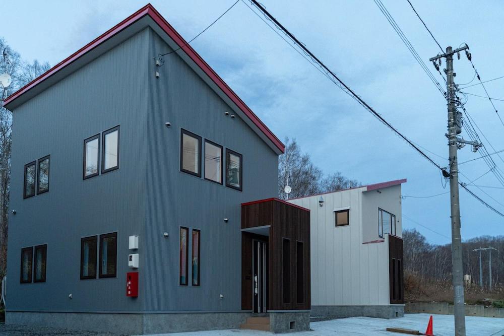 a house with a red roof on top of it at Niseko Yu Villa C in Niseko
